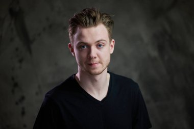 Gri arka planda beyaz bir gencin portresi.