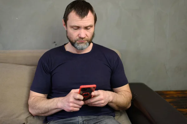 Portré Felnőtt Kaukázusi Férfi Szakállas Használ Telefon Miközben Kanapén Otthon — Stock Fotó