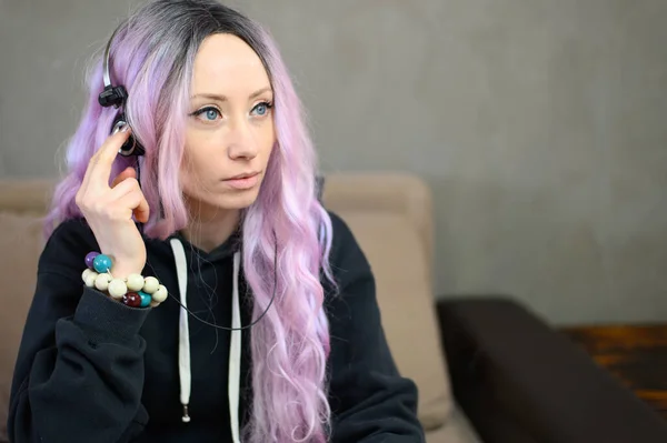 在家里坐在沙发上 一个头戴紫色头发的高加索女孩的画像 侧视图 — 图库照片