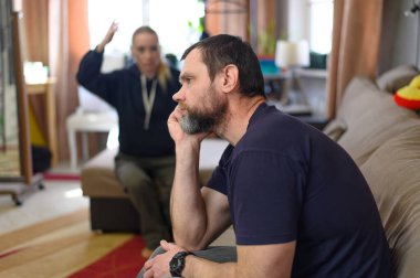 Fotoğrafçı mutsuz. Evdeki kanepede oturan kızı dinliyor.