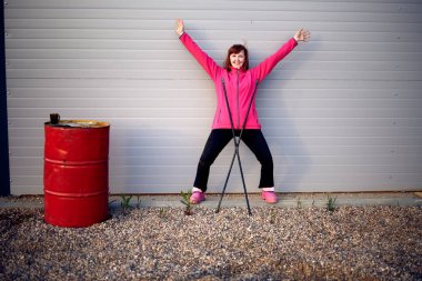 Duvarın yanında bir kadın poz veriyor.