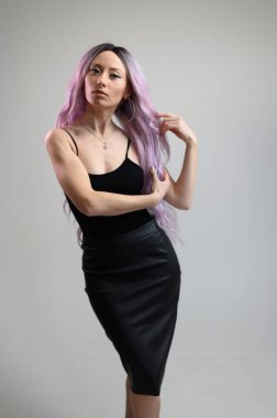 Uzun saçlı beyaz bir kızın tam boy fotoğrafı.