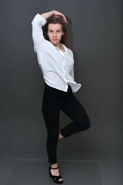 Beyaz bluzlu, dalgalı saçlı, beyaz saçlı beyaz bir kızın tam boy fotoğrafı.