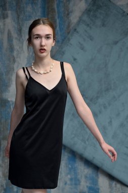 Mavi arka planda poz veren Kafkas kadın modelinin dikey fotoğrafı