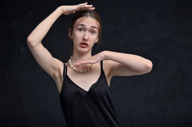 Siyah arka planda poz veren güzel bir kızın portresi.