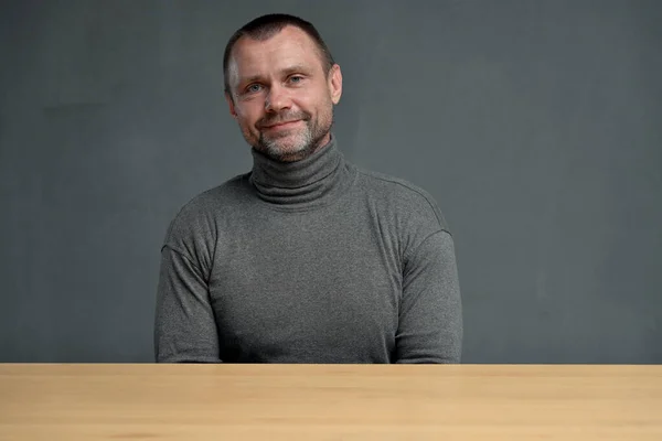 Middelbare Man Zit Aan Tafel Met Een Glimlach — Stockfoto