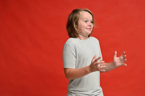 Aranyos Tinédzser Fiú Örül Meglepetés Egy Szürke Póló Piros Háttér — Stock Fotó