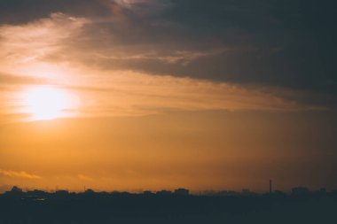 Sabah gökyüzünün yüksek çözünürlüklü fotoğrafı şehrin üzerinde bulutlarda güneşle