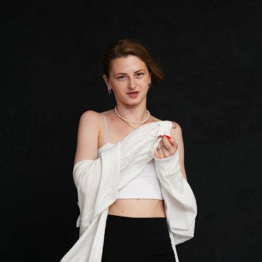 Siyah arka planda açık renk kıyafetlerle konuşan genç bir kız. Evrensel kavram.