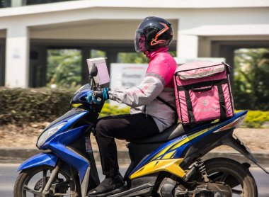 Chiangmai, Tayland - 2 Mart 2021: teslimatçı Gıda Pandası Motercycle 'una biniyor. 1001 numaralı yolda, Chiangmai şehrinden 8 km uzakta..