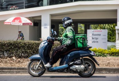 Chiangmai, Tayland - 5 Mart 2021: teslimatçı bir Motercycle of Grab Food 'a biniyor. 1001 numaralı yolda, Chiangmai şehrinden 8 km uzakta..