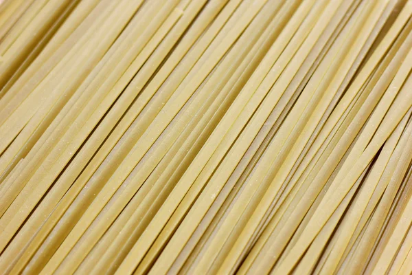 Close-up van ruwe pasta, groene motorkettingen fettuccine — Stockfoto