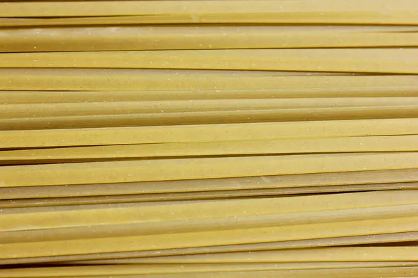 Close-up van ruwe pasta, groene motorkettingen fettuccine — Stockfoto