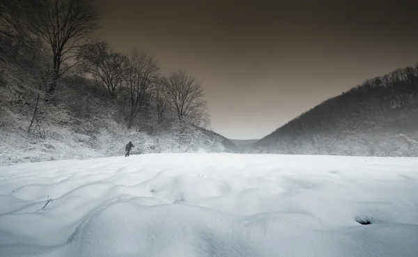 Homem caminhando através da neve — Fotografia de Stock