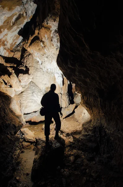 Печера з силуетом дослідника — стокове фото
