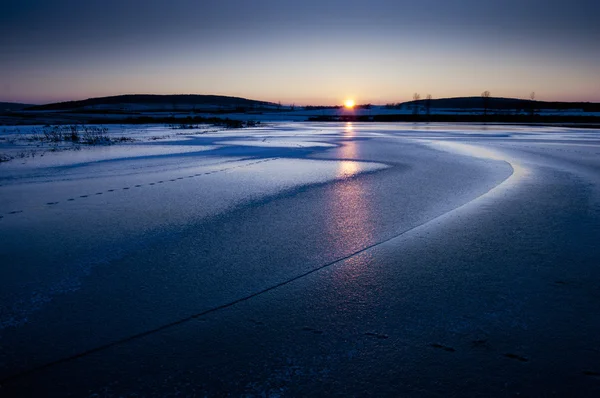 Закат на замерзшем озере — стоковое фото
