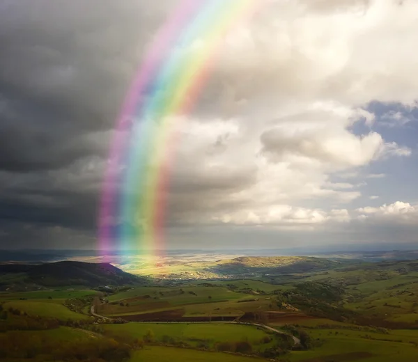 Landscape with rainbow and clouds — Stock Photo, Image