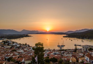 Gün batımında Poros adasındaki Kastro dağ kilisesi ve şehir havadan görünüyor. Yazın Yunanistan