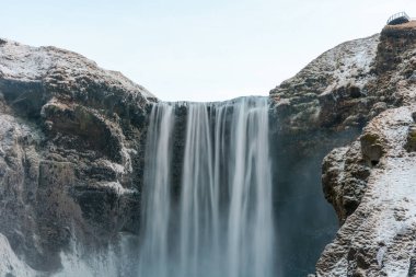 Meşhur Skogafoss şelalesi kışın gün doğumunda. İzlanda 'nın en popüler yerlerinden biri.