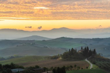 Altın sabah ışığında tepeleri ve hasat tarlaları olan Toskana manzarası Val dorcia, İtalya.