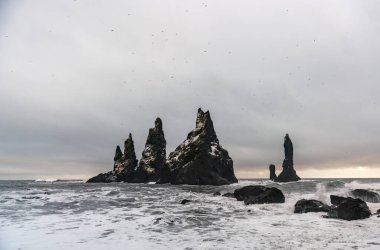 Bazalt kaya oluşumları siyah sahilde Trol ayak parmakları. Fırtınada Reynisdrangar, Vik, İzlanda