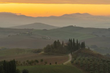 Altın sabah ışığında tepeleri ve hasat tarlaları olan Toskana manzarası Val dorcia, İtalya.