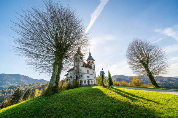 Igreja de St. Volbenka em cores de outono contra um céu azul, Eslovênia, Europa — Fotografia de Stock