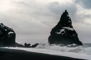 Bazalt kaya oluşumları siyah sahilde Trol ayak parmakları. Fırtınada Reynisdrangar, Vik, İzlanda
