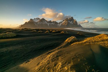 Vestrahorn Dağı ve Stoksnes plajında gün batımı. Vestrahorn, Doğu İzlanda 'da çevre yolu boyunca popüler bir turistik merkezdir..