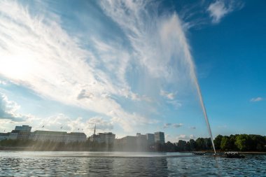 Berrak bir yaz gökyüzünün altında, sakin suların şehri yansıttığı ikonik Alster Çeşmesi 'nin güzelliğini deneyimleyin..