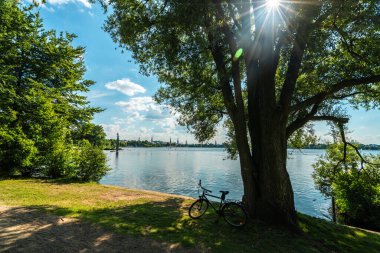 Bereketli yeşillik ve sakin bir atmosferle Hamburg 'daki Alster Nehri' nin yanındaki bu nefes kesici yaz sahnesinin tadını çıkarın..