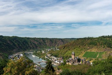 Cochem Kalesi, Moselle Nehri kıyısındaki yemyeşil dağlara kurulmuş göz kamaştırıcı yaz manzarası..