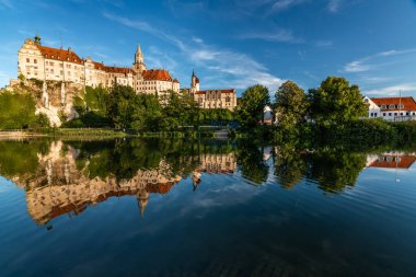 Schloss Sigmaringen 'in yazın sakin suları yansıtan büyüleyici manzarası. Almanya 'da doğa ve mimarinin pitoresk bir sahnesi.