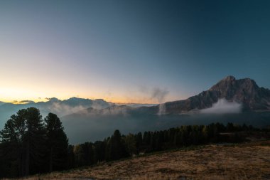 Gün batımında İtalyan Alpleri 'nin dingin güzelliğini tecrübe et. Görkemli dağlar ve yumuşak bulutlar doğayı, huzuru yakalar..