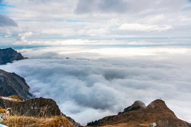 Pilatus Dağı 'ndan muhteşem sonbahar manzarası, İsviçre dağlarını saran bulutları gösteriyor. Seyahat ve doğa meraklıları için mükemmel..