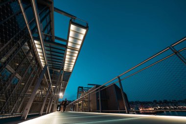 Geceleri Santanders 'ın nefes kesici güzelliğini keşfedin. Modern mimarinin çarpıcı bir aydınlatma köprüsü ve kentsel manzarası var..