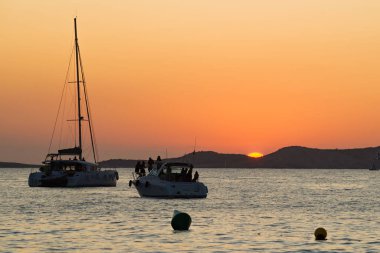 İspanya, İbiza 'da nefes kesici gün batımı manzarası, sakin sularda yelkenliler, seyahat ve doğa meraklıları için mükemmel..