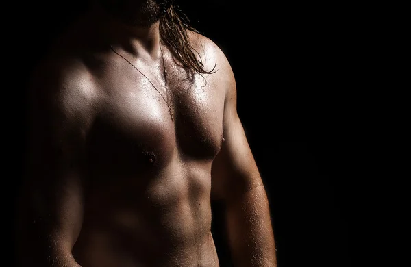 Strong and muscular body of man shaded over black — Stock Photo, Image