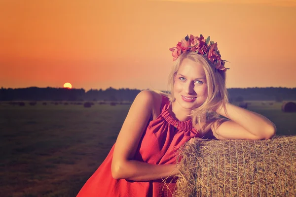 Mulher sexy na pilha de feno no pôr do sol . — Fotografia de Stock