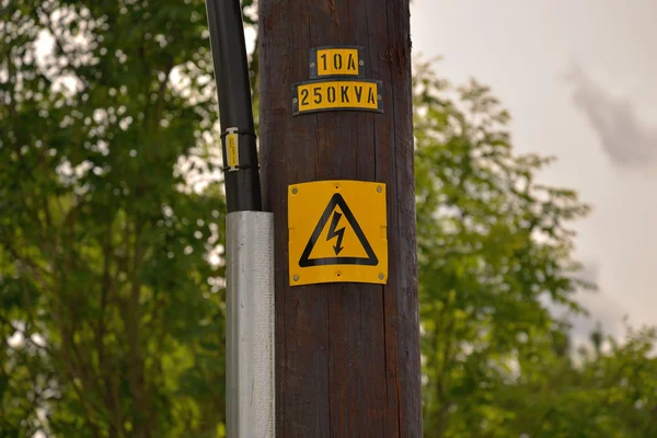 Den varning skyltning på trä elektriska stolpen — Stockfoto