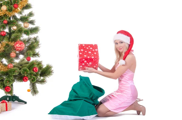 Усміхнена жінка в капелюсі Санта помічника з подарунковою коробкою — стокове фото