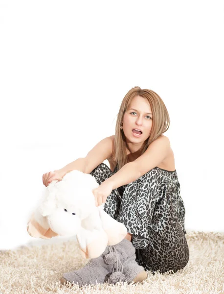 Hermosa mujer vistiendo pijamas abrazando su cordero — Foto de Stock