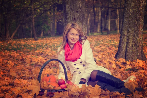 Beautiful young woman posing with pumpkin, apples — Stock Photo, Image