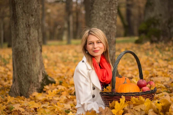 Красива молода жінка позує з гарбузом, яблуками — стокове фото