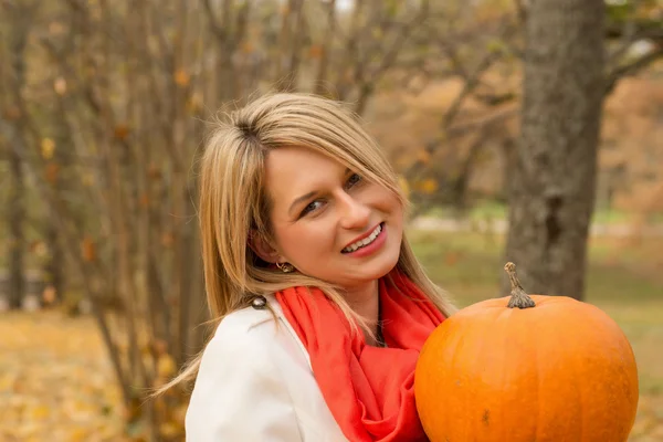 Bella giovane donna in posa con zucca, mele — Foto Stock