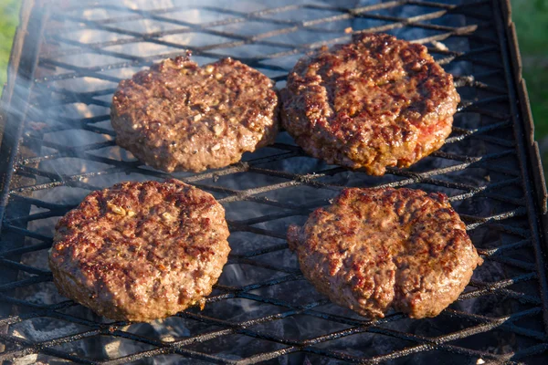Grilled beef burgers close up on a grill — Stock Photo, Image