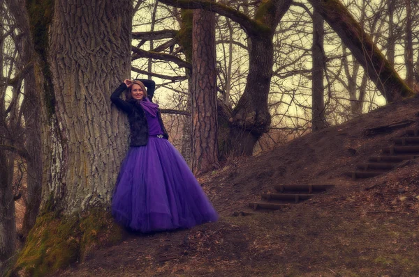 Frau im Wald mit violettem Kleid — Stockfoto
