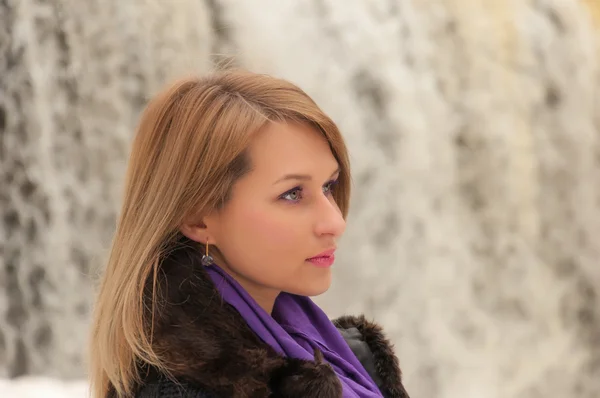 Vrouw staand op de achtergrond van een waterval — Stockfoto