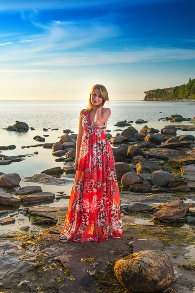 Vrouw in witte bikini poseren in een zee bij zonsondergang — Stockfoto