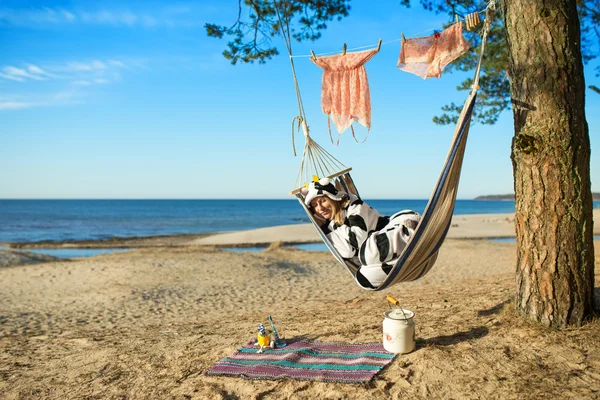 Vrouw in koe pyjama's in een hangmat — Stockfoto